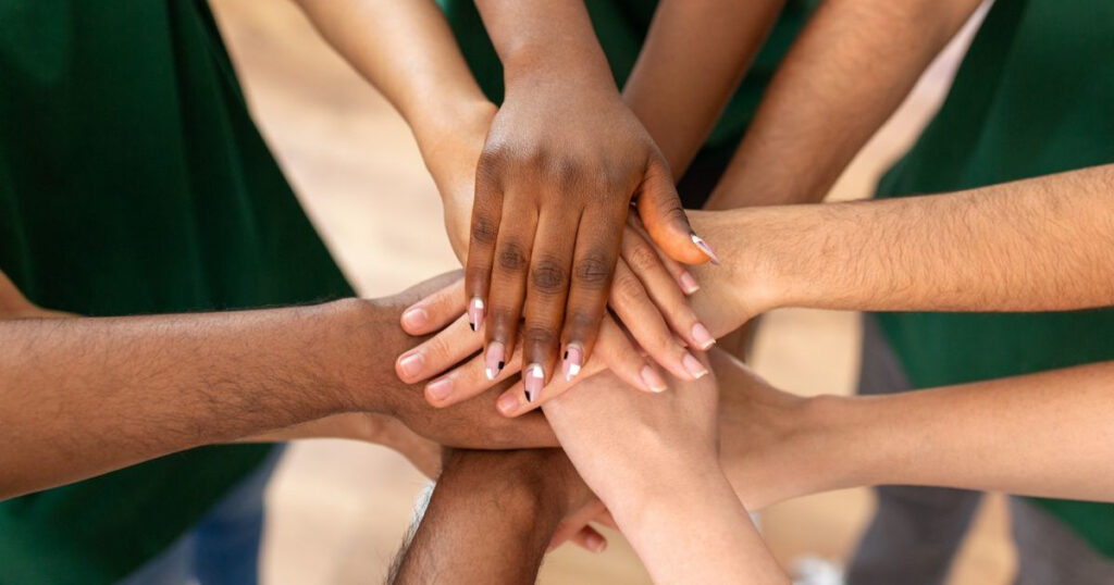 Image with hands in a huddle designating digital marketing strategies for nonprofits, nonprofit organizations